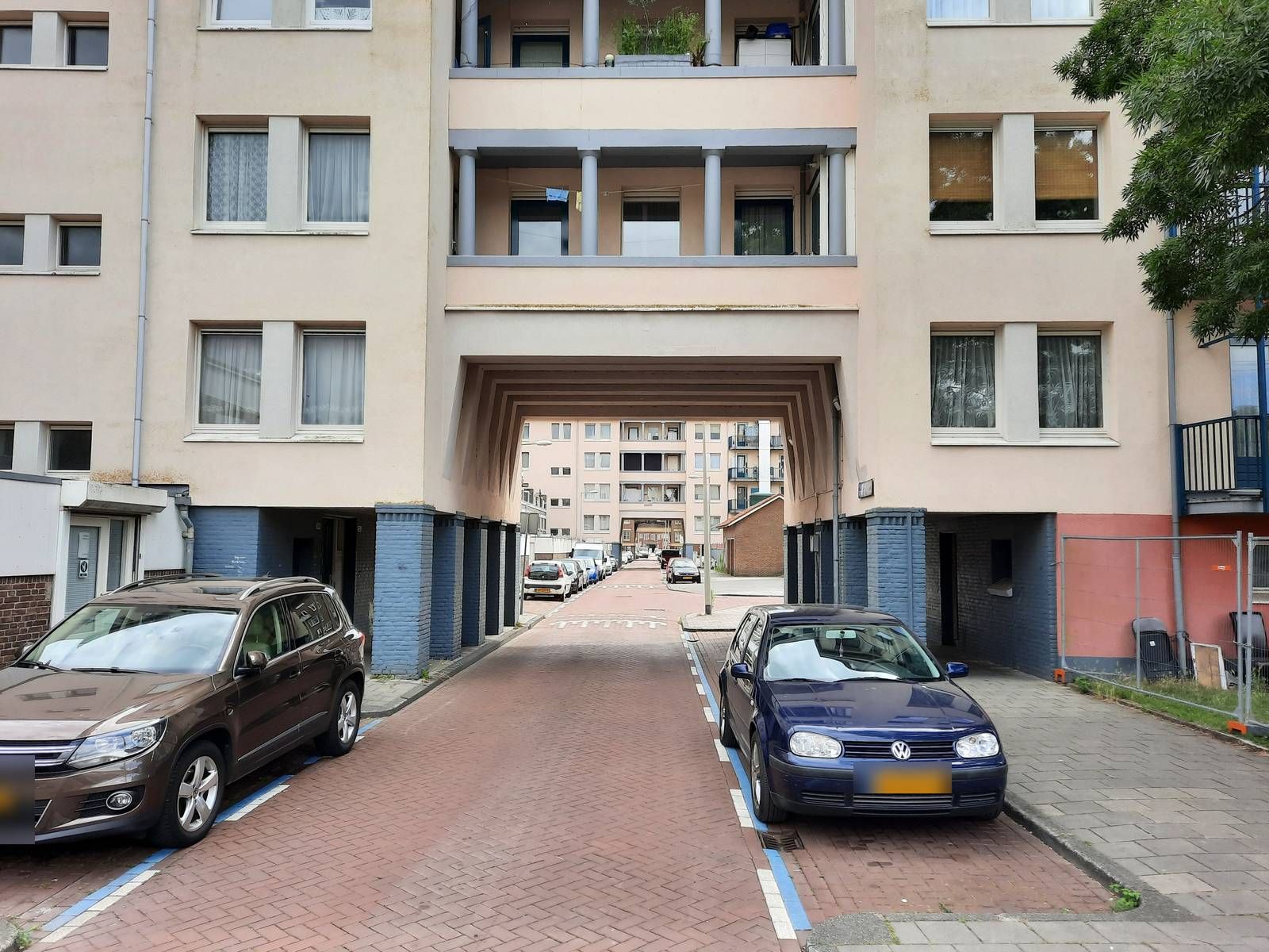 Woonstraat met parkeervakken langs een appartementencomplex